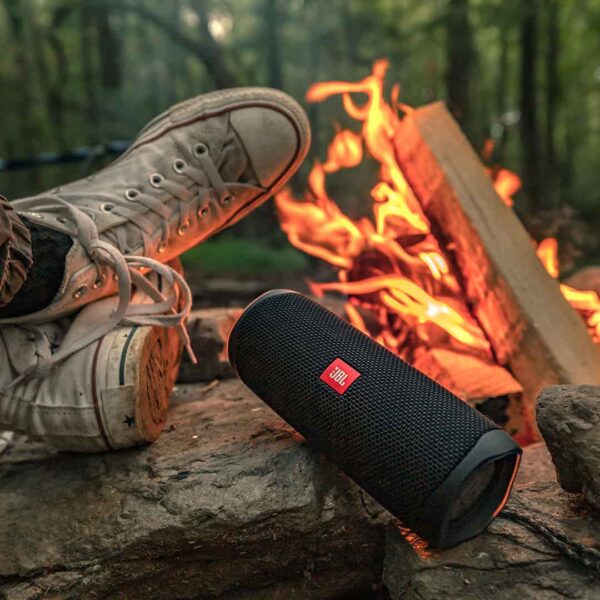 Man seated by the fire with the JBL flip 5